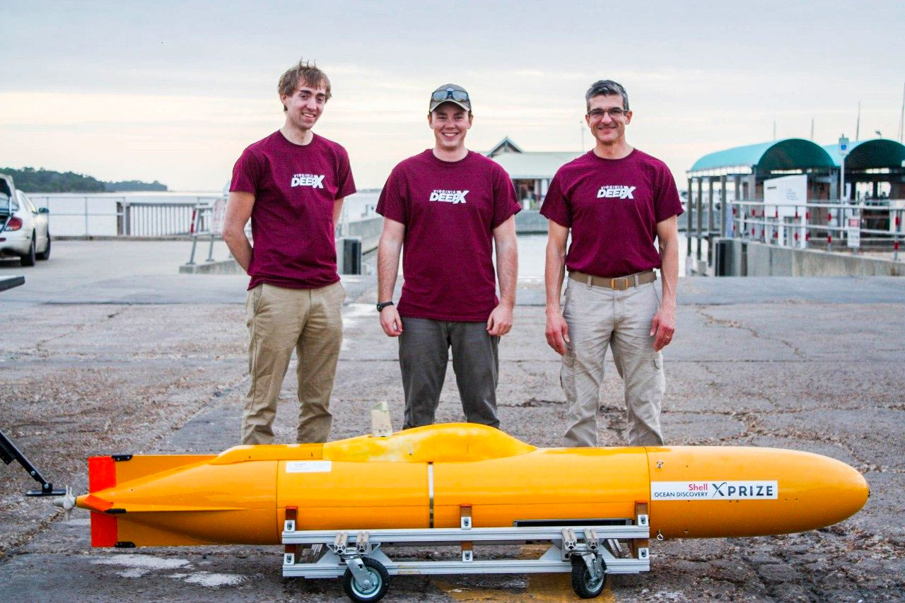 Members of the DeepX team pose outside in front of their submarine.